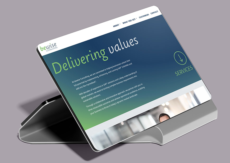 Das Bild zeigt einen Tablet-Ständer mit einem iPad darauf, auf dem die Webseite von bewise Consulting angezeigt wird. Die Webseite selbst präsentiert sich modern und übersichtlich und wirbt mit den Kernkompetenzen des Unternehmens: Beratung und Implementierung von SAP S/4HANA und Add-ons. Der Fokus liegt auf dem Wertversprechen ("Delivering Values") und dem partnerschaftlichen Ansatz zur Erreichung messbarer Erfolge für Kunden.